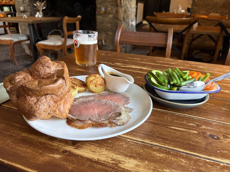 A Sunday roast of beef with a giant Yorkshire pudding, roast potatoes, gravy and vegetables