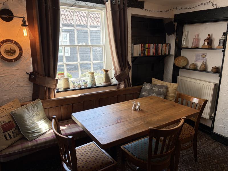 A window table with cushions in the dining room