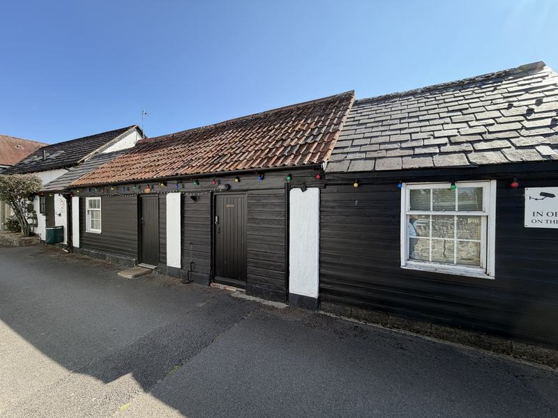 The black weatherboarded barn beside the village lane