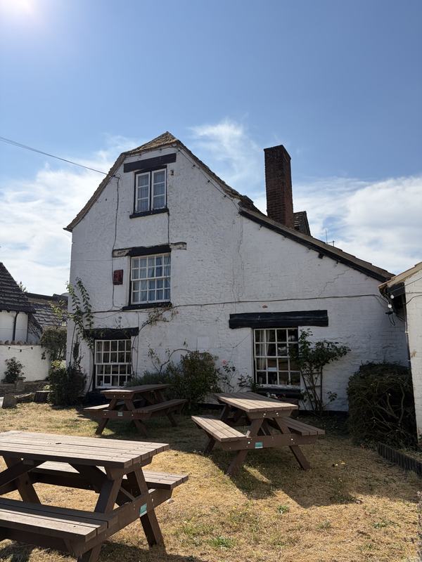 The gable end of the pub and its chimney against a blue sky