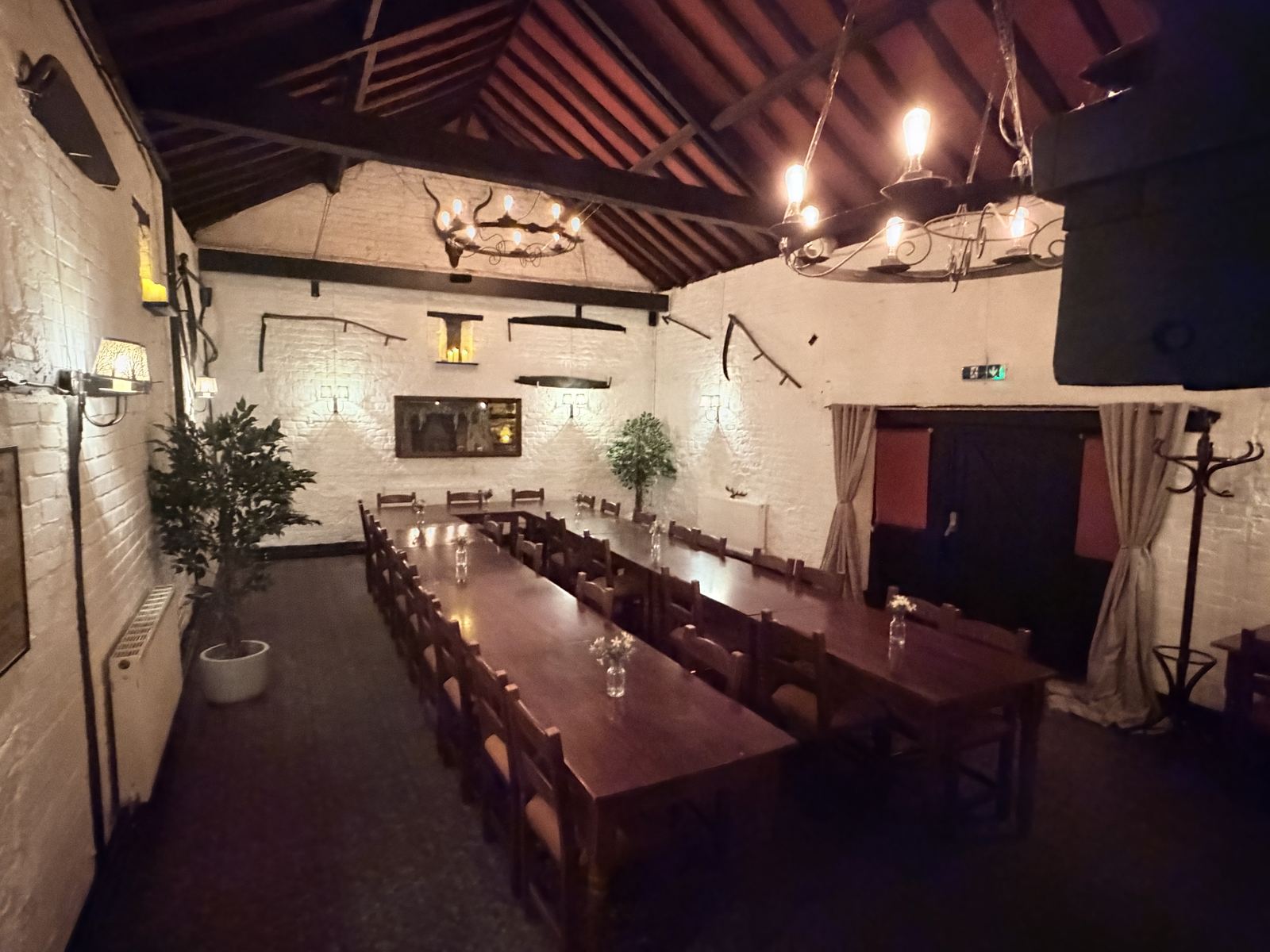 The Medieval Function Room laid with long tables beneath iron chandeliers